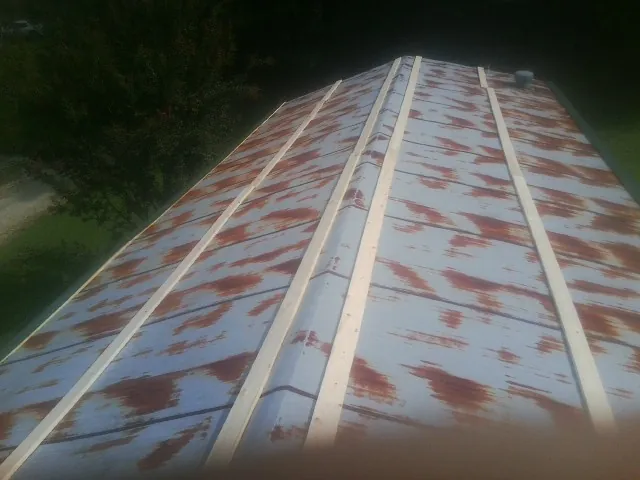 Rusted metal roof panels with new wood purlins before replacement — Storm Damage Roof Repair in Stoneboro by Roofing Brothers