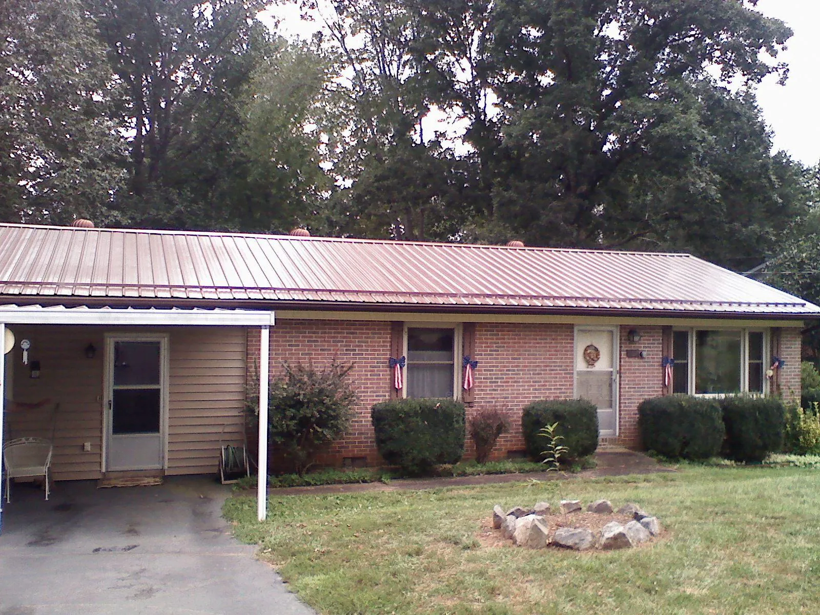 Bronze metal roof and carport on a brick ranch home — Roof Repair work by our crew in Stoneboro