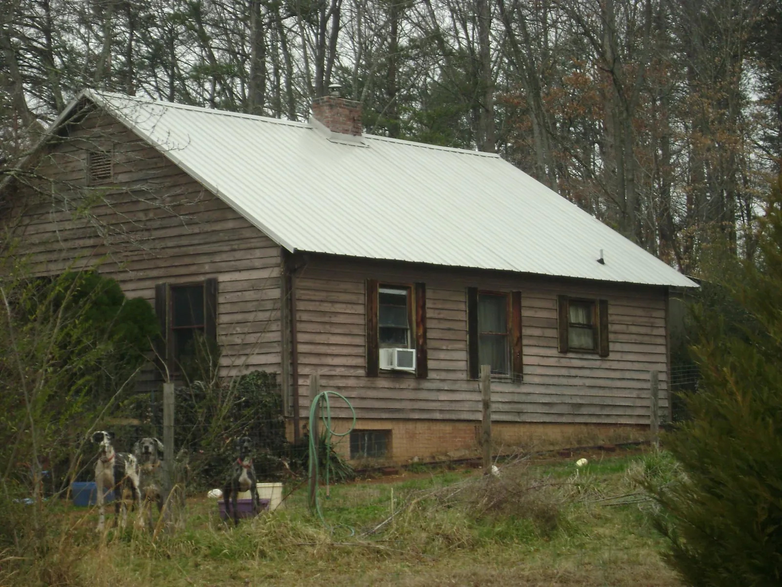 White metal roof on an old wood sided farmhouse, from a Metal Roof Installation job in Stoneboro